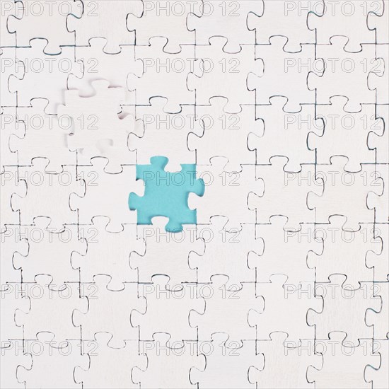 White jigsaw on a blue background, missing parts, working together as a team, searching for