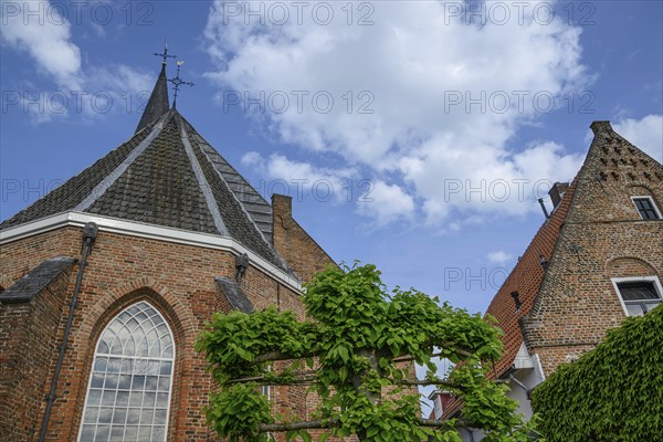 Red brick church with gothic architecture and high towers, someone in a village in good weather,
