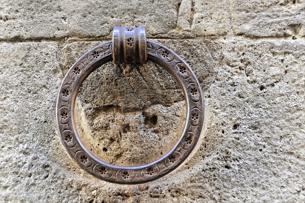 Volterra, Tuscany, Italy, Europe, Close-up of an antique metal door knocker on a stone wall, Europe