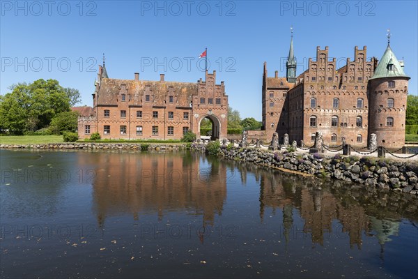 Egeskov moated castle with gatehouse, Kvaerndrup near Svenborg, Svendburg, reflection, flag,
