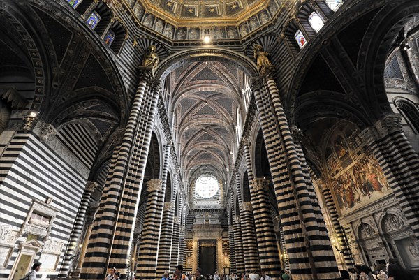 The central nave of the cathedral with its black and white striped marble columns, cross and round