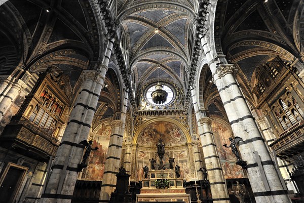 The central nave of the cathedral with its black and white striped marble columns, cross and round