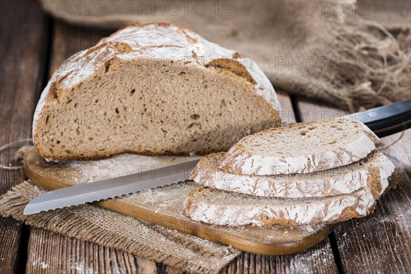 Fresh baked Loaf of Bread on an old wooden table