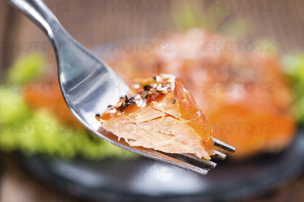 Piece of Smoked Salmon on a fork (detailed close-up shot)