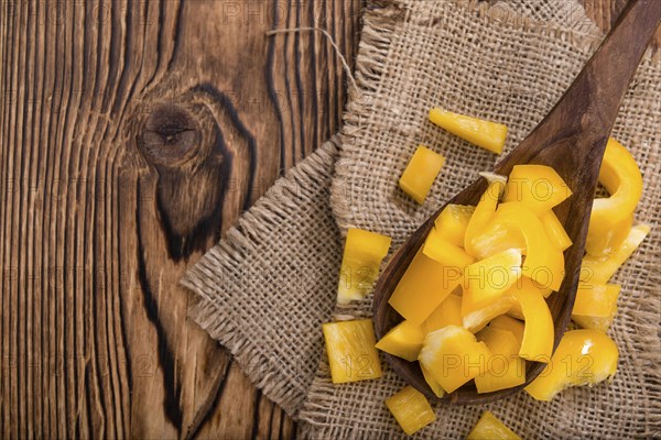 Sliced yellow Peppers (selective focus) on vintage wooden background
