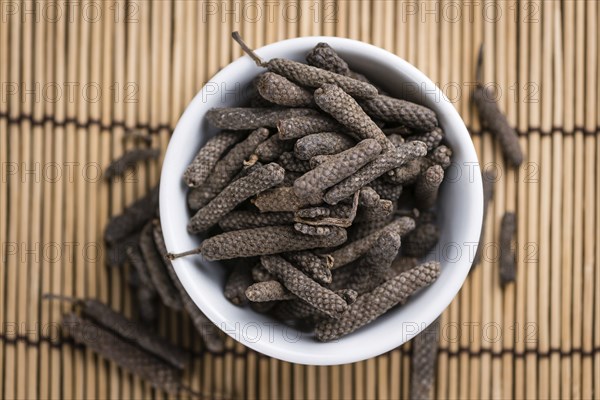 Long Pepper (dried) on an old wooden table (selective focus)