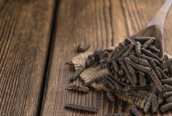 Long Pepper (dried) on an old wooden table (selective focus)