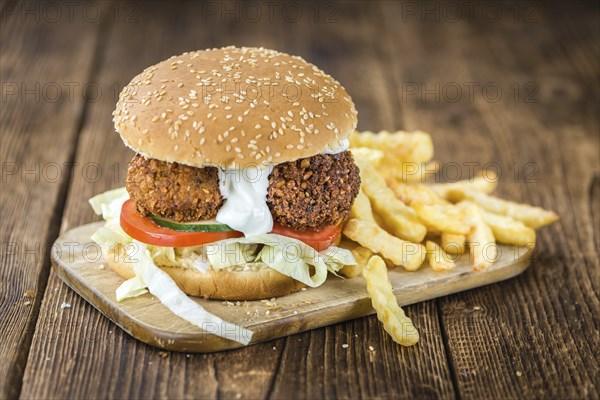 Fresh madeFalafel Burger on wooden background (close-up shot, selective focus)