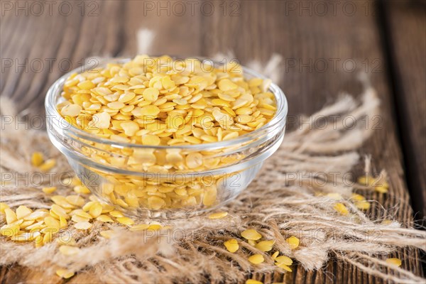 Portion of Yellow Lentils on vintage wooden background
