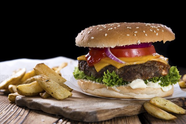 Homemade Burger with French Fries on an old wooden table