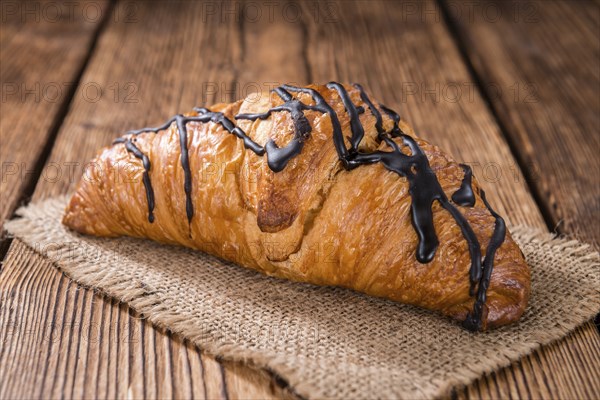 Fresh made Chocolate Croissants (close-up shot) on wooden background