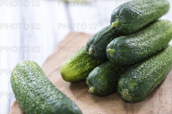 Some small Cucumbers (close-up shot) on vintage wooden background