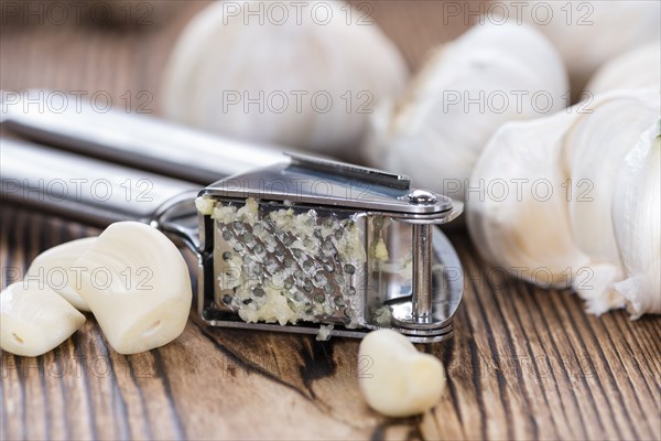 Crushed Garlic (close-up shot) on rustic wooden background