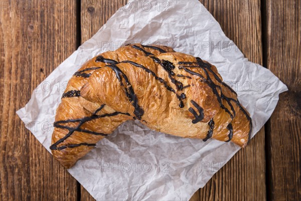 Fresh made Chocolate Croissants (close-up shot) on wooden background