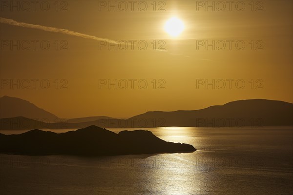 Golden sunset over calm sea with silhouetted archipelago, Makri Island, Alimia Island, Chalki