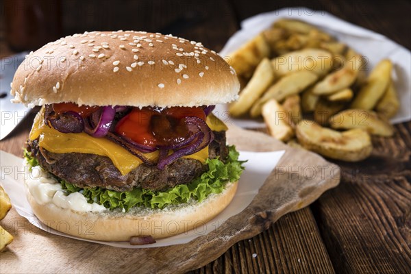 Homemade Burger with French Fries on an old wooden table