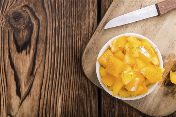 Sliced yellow Peppers (selective focus) on vintage wooden background
