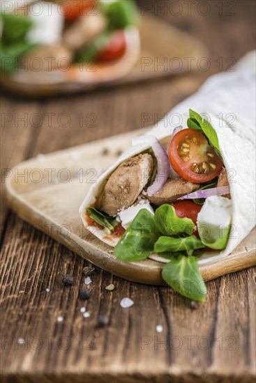 Chicken Wrap (close-up shot, selective focus) on vintage wooden background