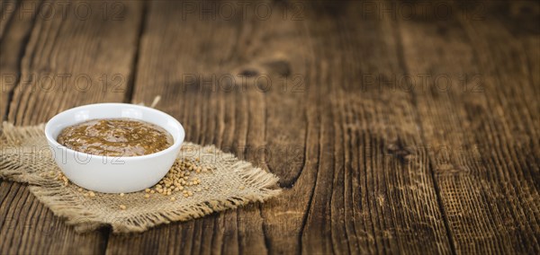 Fresh made German Cuisine (sweet Mustard) on a vintage background (close-up shot)