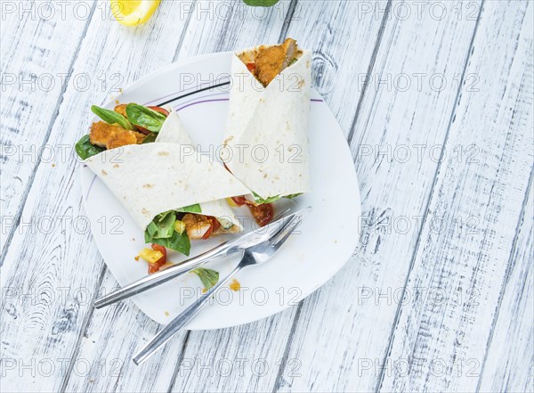 Chicken Wrap (detailed close-up shot, selective focus) on wooden background