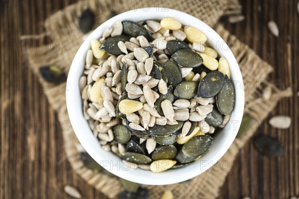 Old wooden table with mixed Seeds (close-up shot, selective focus)