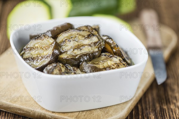 Zucchinis (grilled) as high detailed close-up shot on a vintage wooden table (selective focus)