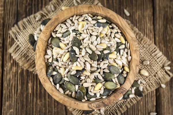 Old wooden table with mixed Seeds (close-up shot, selective focus)