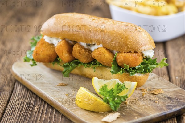 Fresh made Snack (Sandwich with Fish Sticks) on an old wooden table