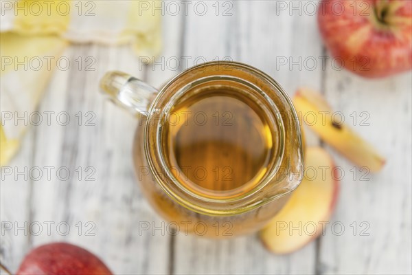 Apple Cider as high detailed close-up shot on a vintage wooden table (selective focus)