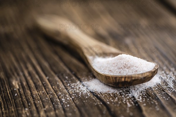 Pink Himalayan Salt on rustic wooden background (close-up shot)