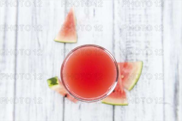 Homemade Watermelon Smoothie on an wooden table (selective focus) as detailed close-up shot