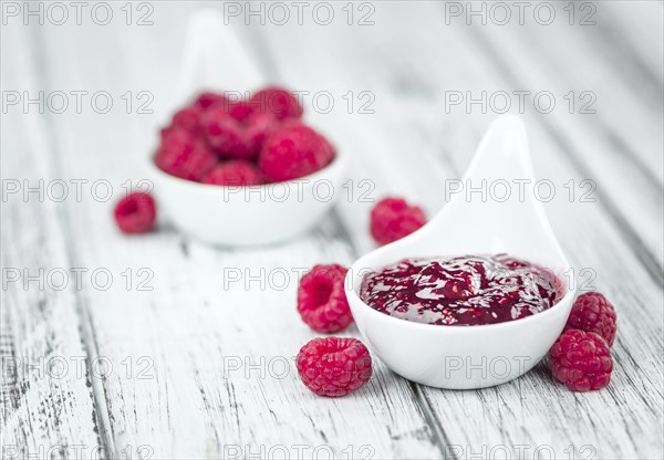 Fresh made Raspberry Jam on an old and rustic wooden table, selective focus, close-up shot