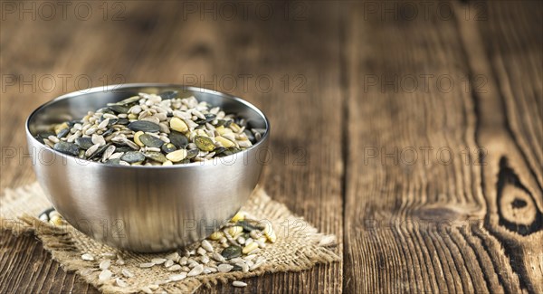 Old wooden table with mixed Seeds (close-up shot, selective focus)