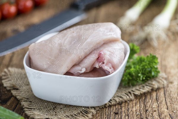 Raw Chicken Cutlet (close-up shot) on wooden background