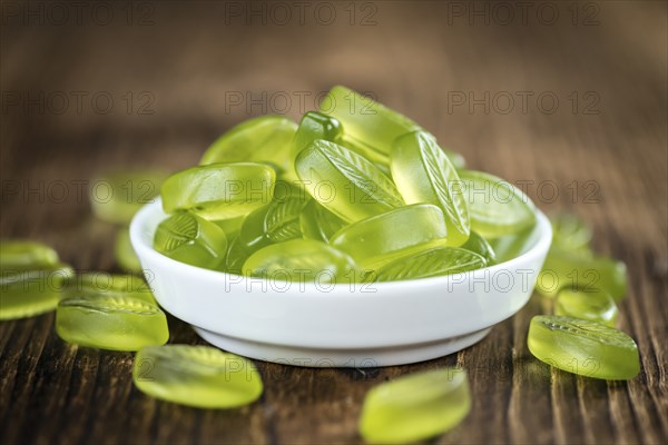 Lime candy (selective focus) on wooden background (close-up shot)