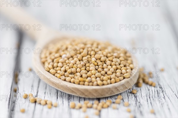 Seeds (Mustard) as high detailed close-up shot on a vintage wooden table (selective focus)