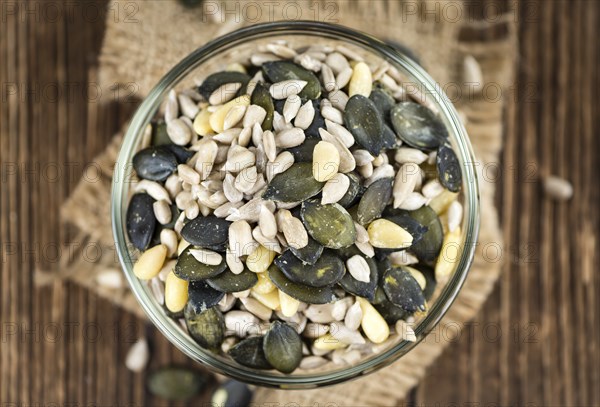 Portion of mixed Seeds (close-up shot, selective focus) on wooden background