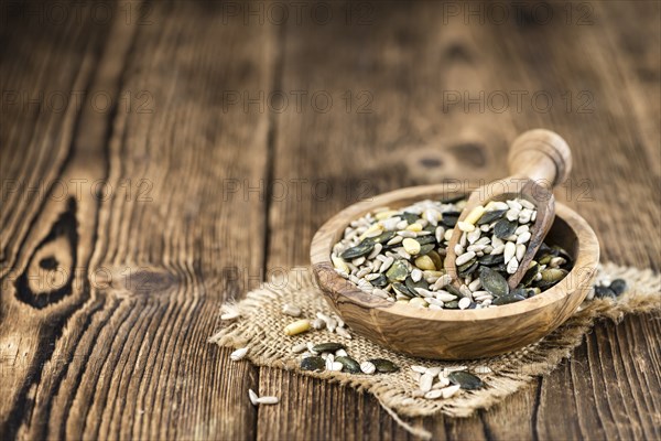 Old wooden table with mixed Seeds (close-up shot, selective focus)