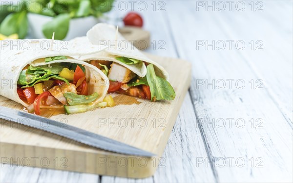 Portion of Chicken Wraps (selective focus) on an old wooden table