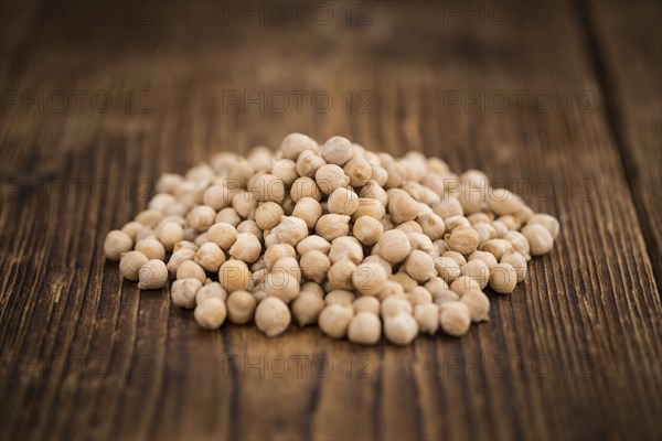 Dried Chickpeas as high detailed close-up shot on a vintage wooden table, selective focus