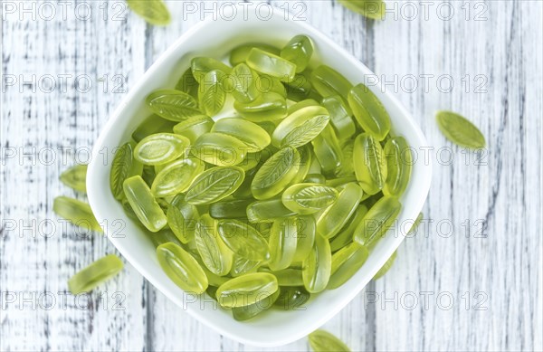 Lime candy (selective focus) on wooden background (close-up shot)
