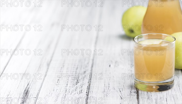 Apple Juice on an old wooden table as detailed close-up shot (selective focus)