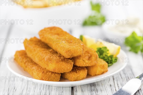 Fisch Sticks (close-up shot) on an old wooden table (selective focus)