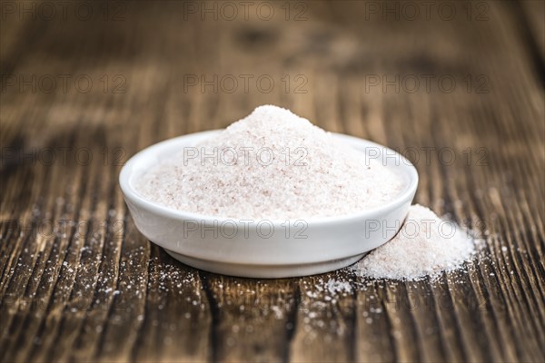Pink Himalayan Salt on rustic wooden background (close-up shot)