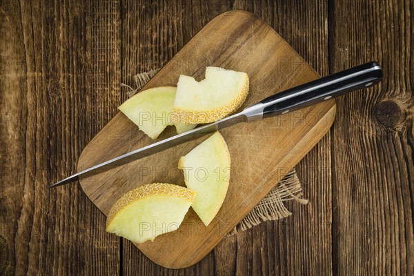 Honeydew Melon on an old wooden table as detailed close-up shot (selective focus)