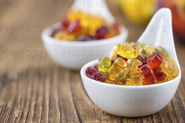 Wooden table with Gummy Bears (close-up shot, selective focus)