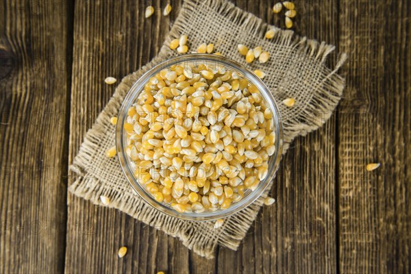 Portion of Corn (detailed close-up shot) on wooden background (selective focus)