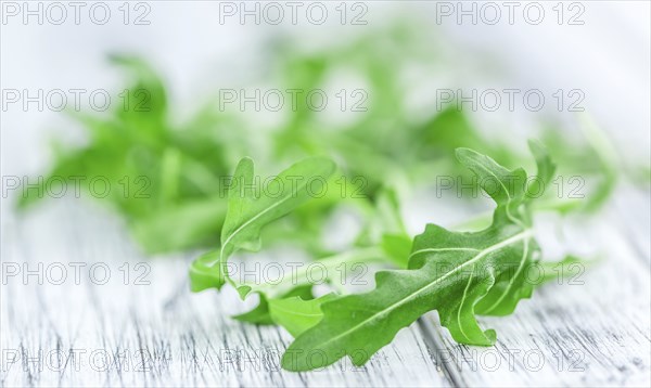 Fresh Arugula on an old wooden table as detailed close-up shot
