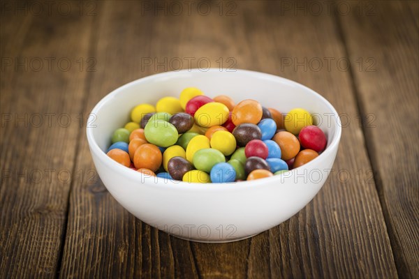 Fresh made Cocolate coated Peanuts on a vintage background (close-up shot)