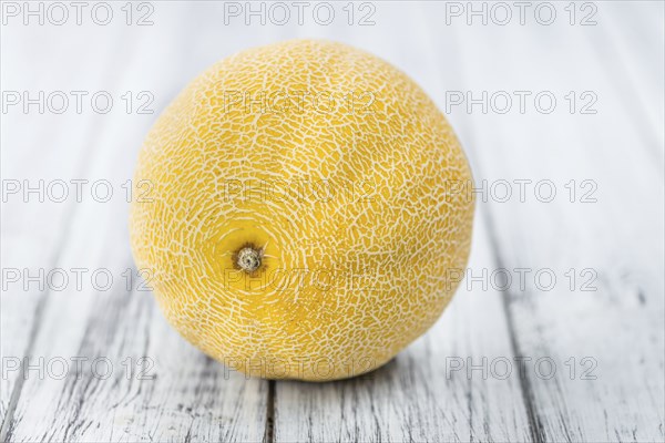 Honeydew Melon on an old wooden table as detailed close-up shot (selective focus)